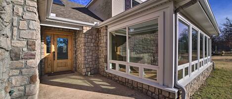 A house with a stone facade, a wooden front door, and large windows.