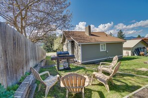 A backyard with a wooden fence, a small house, and three Adirondack chairs. - Cle Elum Vacation Rental - Walk Downtown! (Cle Elum)