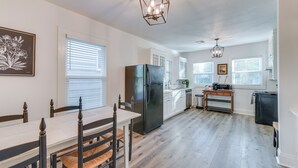 A modern kitchen with a central island, white cabinetry, and a black refrigerator. - 3 Mi to Baylor U: Home w/ Shared Yard (Waco)