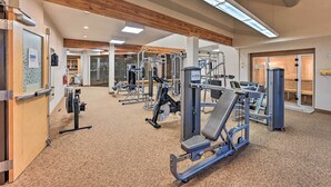 A gym with various exercise machines, wooden ceiling beams, and a carpeted floor. - Cozy & Chic Mountain Condo w/ Community Perks (Fraser)