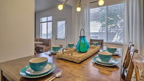 A dining area with a wooden table set for four, a woven placemat, and teal dinnerware.