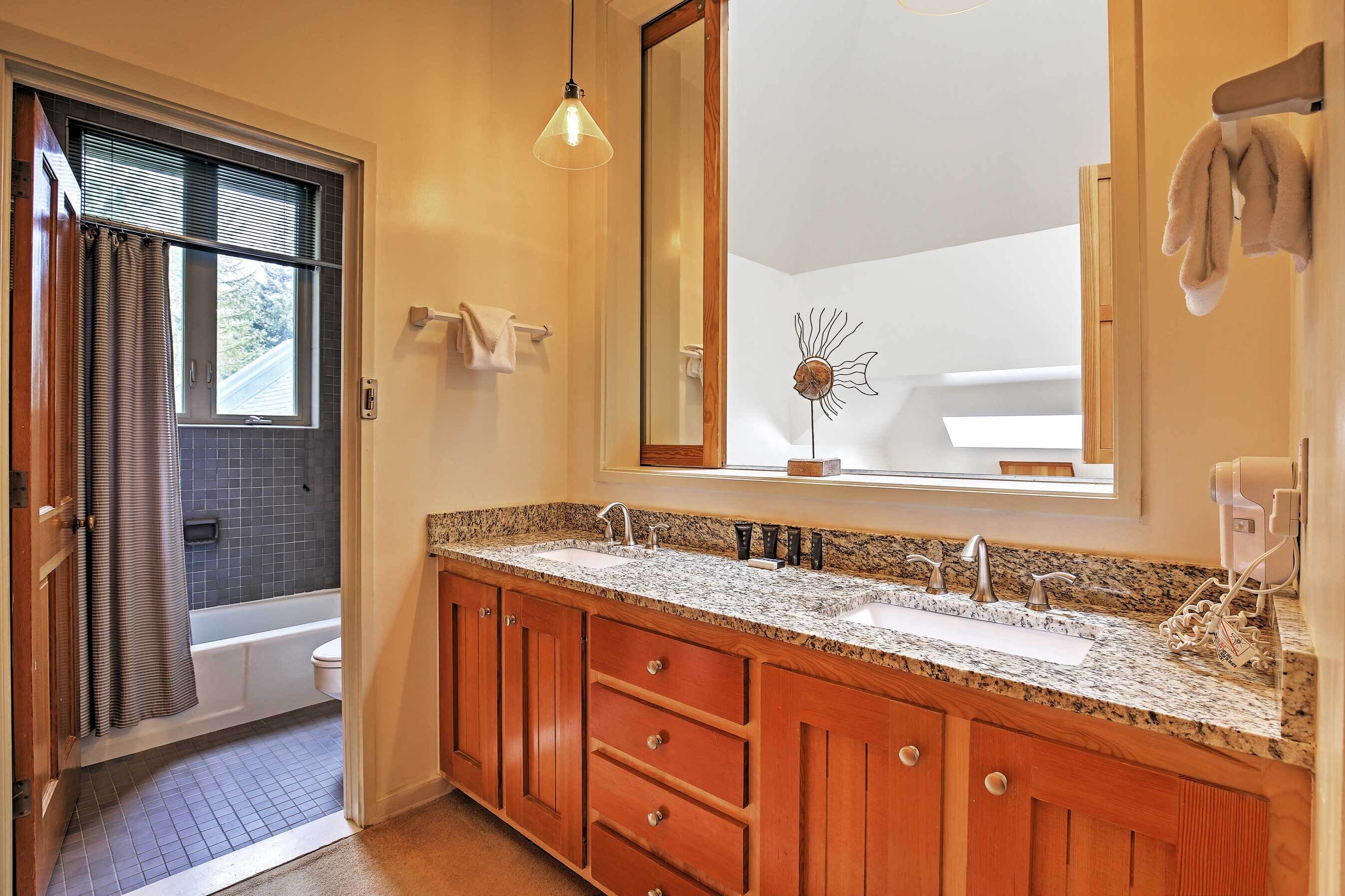 A bathroom with a double sink vanity, a large mirror, and a shower area.