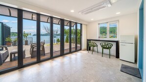 A modern kitchen with a view of the lake, a dining area with chairs, and a refrigerator. - Changwon 055 Poolvilla (Changwon)