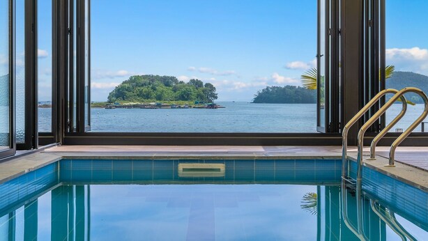 A pool with a view of a small island and water. - Changwon 055 Poolvilla (Changwon)