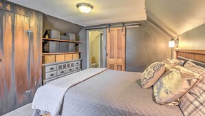 Una camera da letto con un letto, una cassettiera, un armadio e una porta scorrevole.