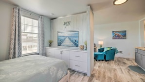A bedroom with a bed, a desk, a chair, a painting, and a window with curtains. - 1 Block to Long Beach! Adorable Downtown Studio (Long Beach)