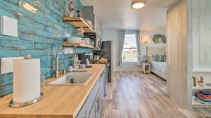 A modern kitchen with a blue brick backsplash, wooden countertops, and a central island. - 1 Block to Long Beach! Adorable Downtown Studio (Long Beach)