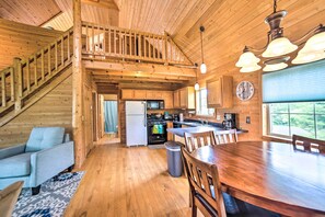A spacious kitchen with wooden floors and a dining area. - Secluded Lake Michigan Home: Private Fire Pit (Manistique)