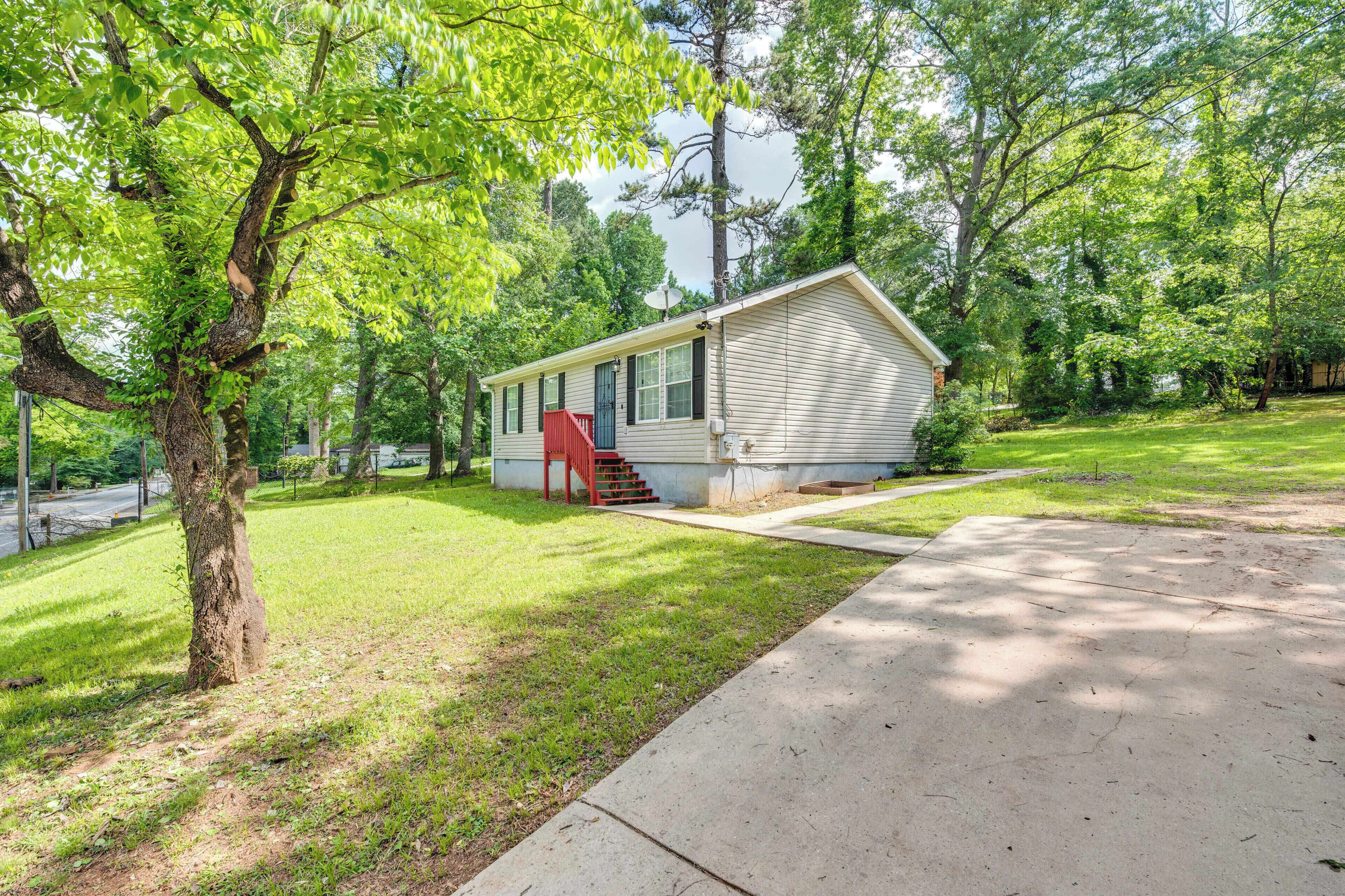 A single-story mobile home with a red door and a small front yard.