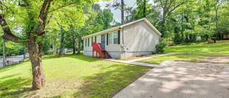 A single-story mobile home with a red door and a small front yard.