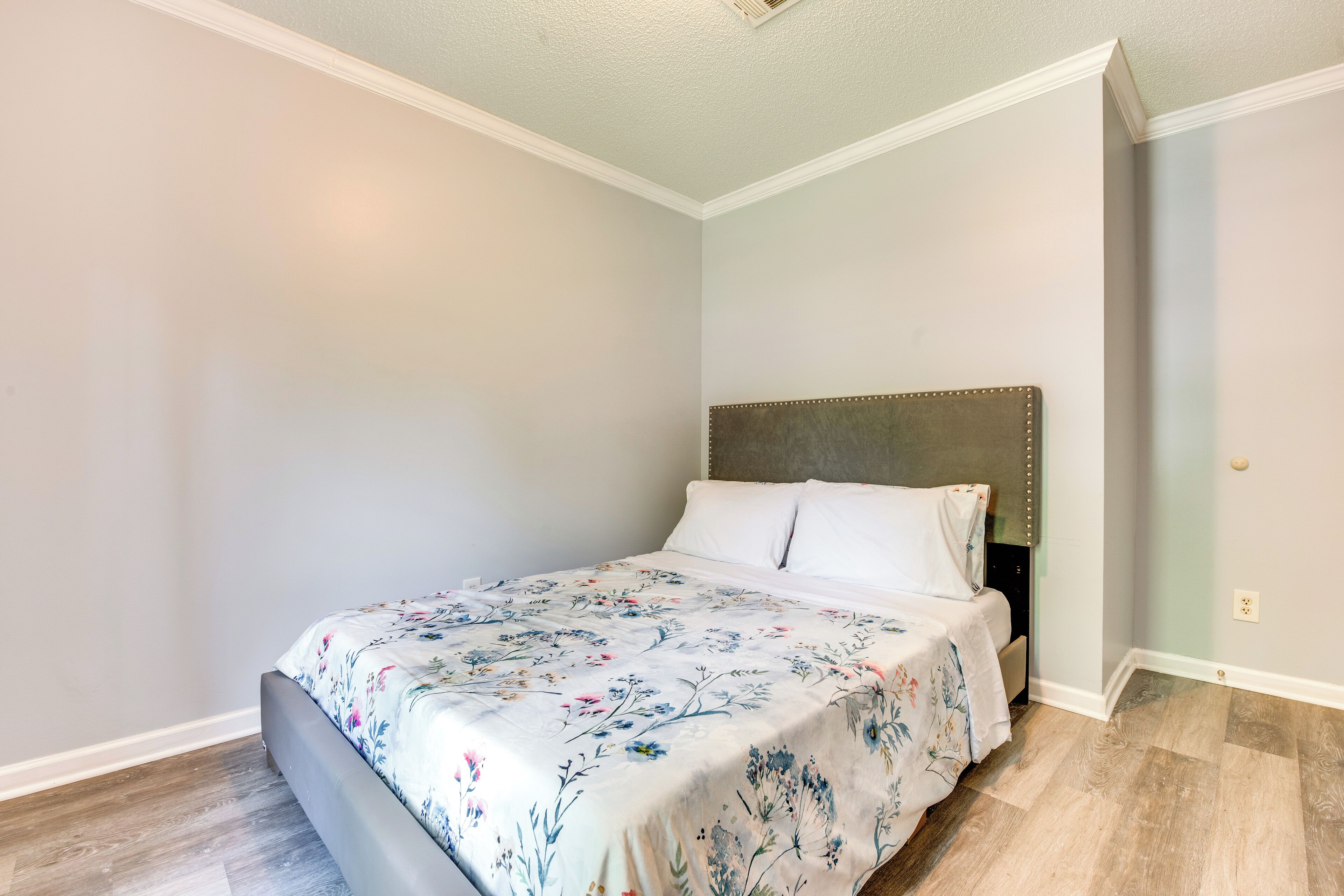 Une chambre à coucher avec un lit, une tête de lit et une table de chevet.