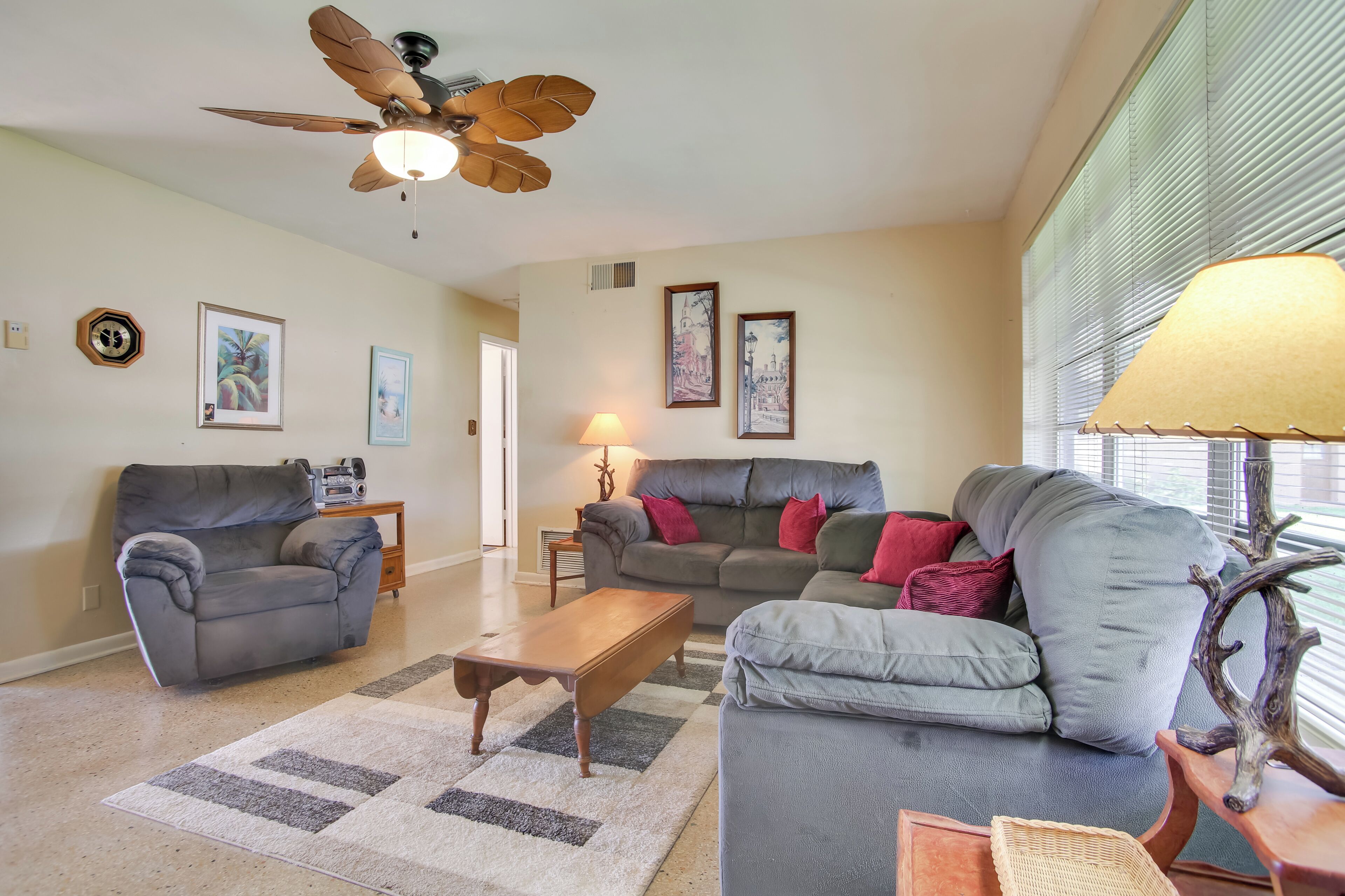 A living room with two sofas, a coffee table, and a ceiling fan.