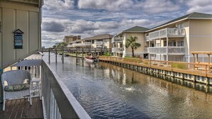 Et hotel ved vandet med udsigt til en kanal, en bådehavn og et skilt, der viser regler for stranden.