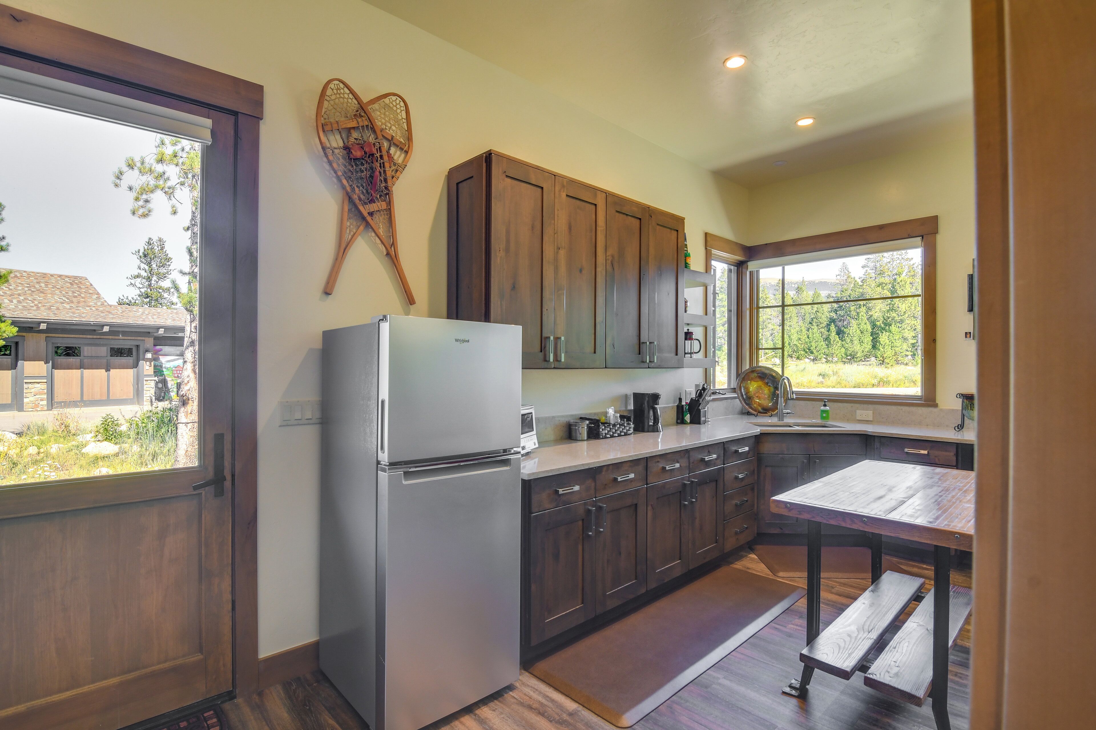 Una cocina con armarios de madera, un refrigerador de acero inoxidable y una ventana con vistas al exterior.