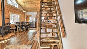 A wooden interior with a staircase, dining area, and kitchen. - Tasteful Log Cabin Retreat on Lake Pagosa! (Pagosa Springs)