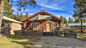 A rustic log cabin with a porch, a covered entryway, and a gravel driveway. - Tasteful Log Cabin Retreat on Lake Pagosa! (Pagosa Springs)
