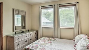 A bedroom with a bed, dresser, mirror, and two windows with curtains. - P'hoa Home 4 Mi to Kilauea Caverns of Fire! (Pahoa)