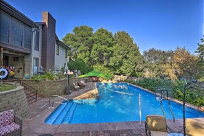 Ein Swimmingpool mit Basketballkorb, umgeben von einer Ziegelterrasse, Gartenmöbeln und einer Ziegelmauer.