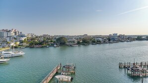 Un port de plaisance avec des bateaux amarrés, un ciel dégagé et une vue sur la ville en arrière-plan.