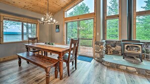 Une pièce spacieuse avec une table à manger en bois, des chaises et une cheminée en pierre.