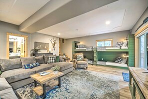 A modern living room with a sectional sofa, a wooden coffee table, and a green bunk bed with a ladder. - Bikes, Grill & Views: Luxe Truckee Cabin! (Truckee)