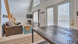 A modern living room with a wooden bench, a brown leather sofa, and a staircase. - Leavenworth Vacation Rental Near Downtown! (Leavenworth)