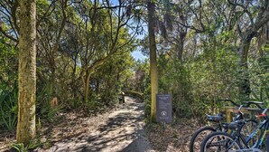 A forested path with a sign and a bicycle. - Blissful Kiawah Island Escape: Walk to the Beach! (Kiawah Island)