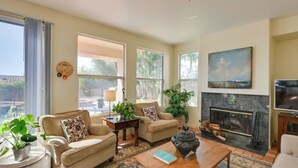Una sala de estar con chimenea, dos sofás, una mesa de centro y un televisor.