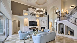 A spacious living room with a large sectional sofa, a glass coffee table, and a fireplace. - Luxe Cape Coral Escape w/ Boat Dock + Cabana! (Cape Coral)