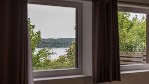 Une fenêtre donnant sur un lac et une forêt.