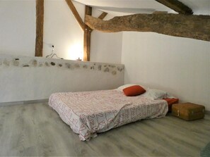 Un dormitorio con una cama, una mesita de noche y un aparador.