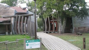 A rustic wooden building with a sign indicating it is the Courant d'Huchêt, a nature reserve and guesthouse. - Lou Parc - Leon - Gîte (LEON)