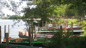 A dock with several boats moored in calm water, surrounded by greenery and trees. - Lou Parc - Leon - Gîte (LEON)