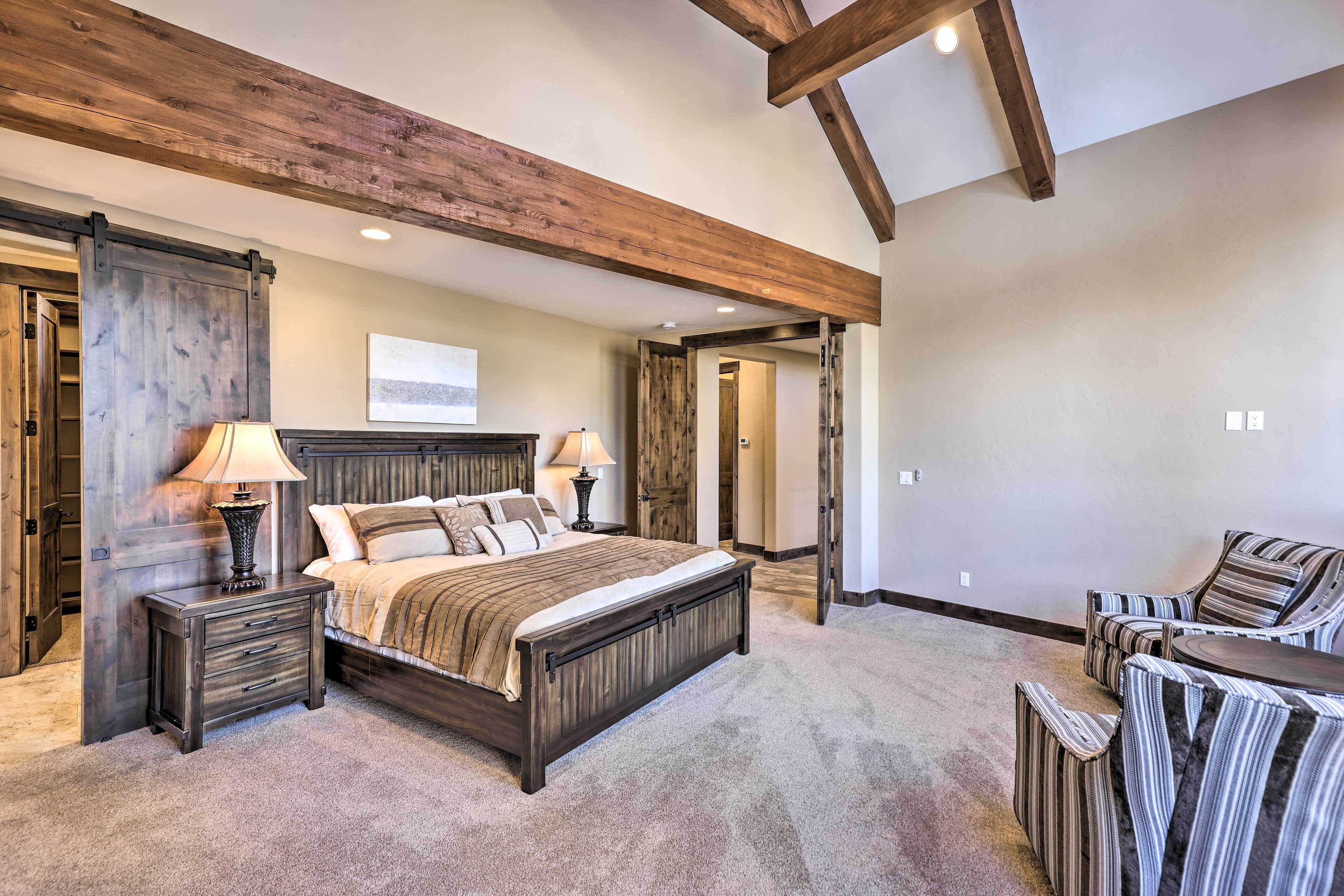 A bedroom with a large bed, bedside tables, a chair, and a desk.