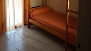 Habitación con literas, ventana y cortinas.