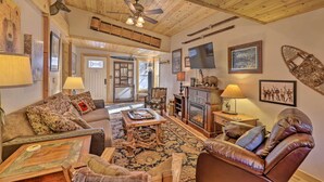 A cozy living room with a fireplace, leather furniture, and wooden ceiling beams. - 6 Mi to Slopes! Mtn-view Breck Gem w/ Resort Perks (Breckenridge)