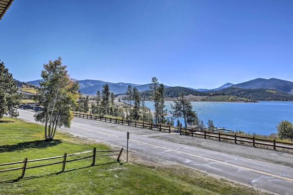 A road leading to a body of water with mountains in the background.