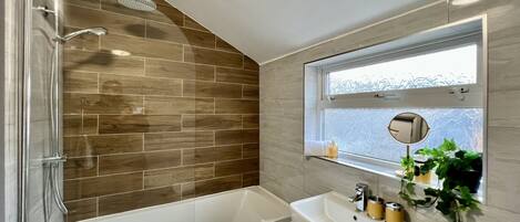 Un baño moderno con ducha, bañera y lavamanos.