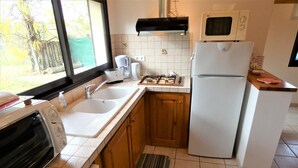 A compact kitchen with a built-in oven, a microwave, a sink, and a stove. - L'ecureuil - Soustons (SOUSTONS)