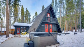 A cabin with a steep roof, red doors, and a small balcony. - Near Trails & Breweries: Cabin w/ Hot Tub in Breck (Breckenridge)