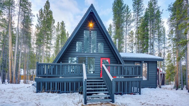 A cabin with a steep staircase, a red door, and a deck. - Near Trails & Breweries: Cabin w/ Hot Tub in Breck (Breckenridge)