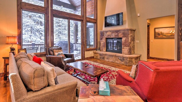 A cozy living room with a fireplace, large windows, and comfortable seating. - Blue River Home w/ Hot Tub, 6 Mi to Skiing! (Breckenridge)