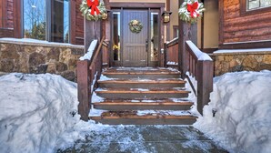 A wooden staircase leading to a door with a wreath, flanked by snowbanks. - Blue River Home w/ Hot Tub, 6 Mi to Skiing! (Breckenridge)