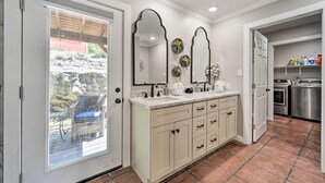 A bathroom with a large vanity, double sinks, and a mirror.