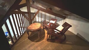 A wooden dining table with chairs in a room with a sloped ceiling and wooden beams. - Le Gemmeur - SOUSTONS (SOUSTONS)