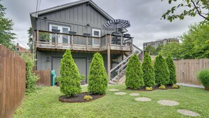 A two-story house with a balcony, a wooden deck, and a staircase leading to the upper level.