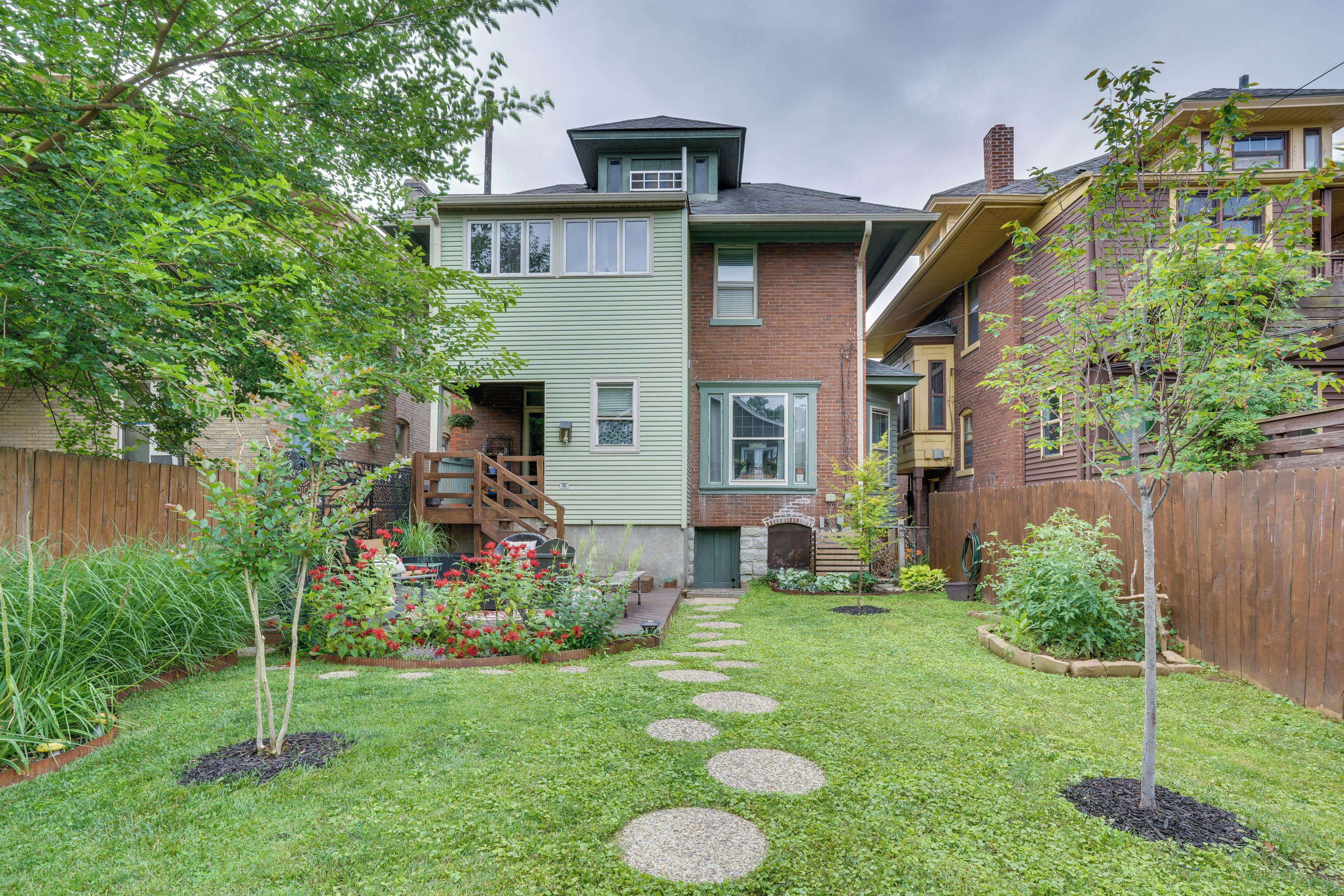 A residential area with a well-maintained lawn, a stone pathway, and a wooden fence.
