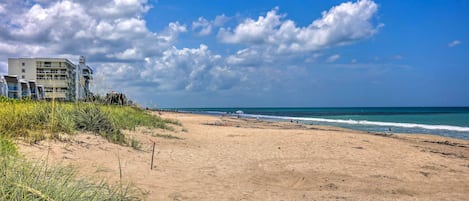 Una playa con un edificio al fondo.
