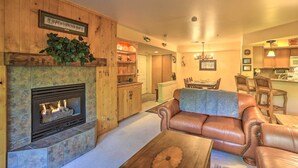 Ein Wohnzimmer mit Kamin, Ledersofa und einem Essbereich mit Stühlen.