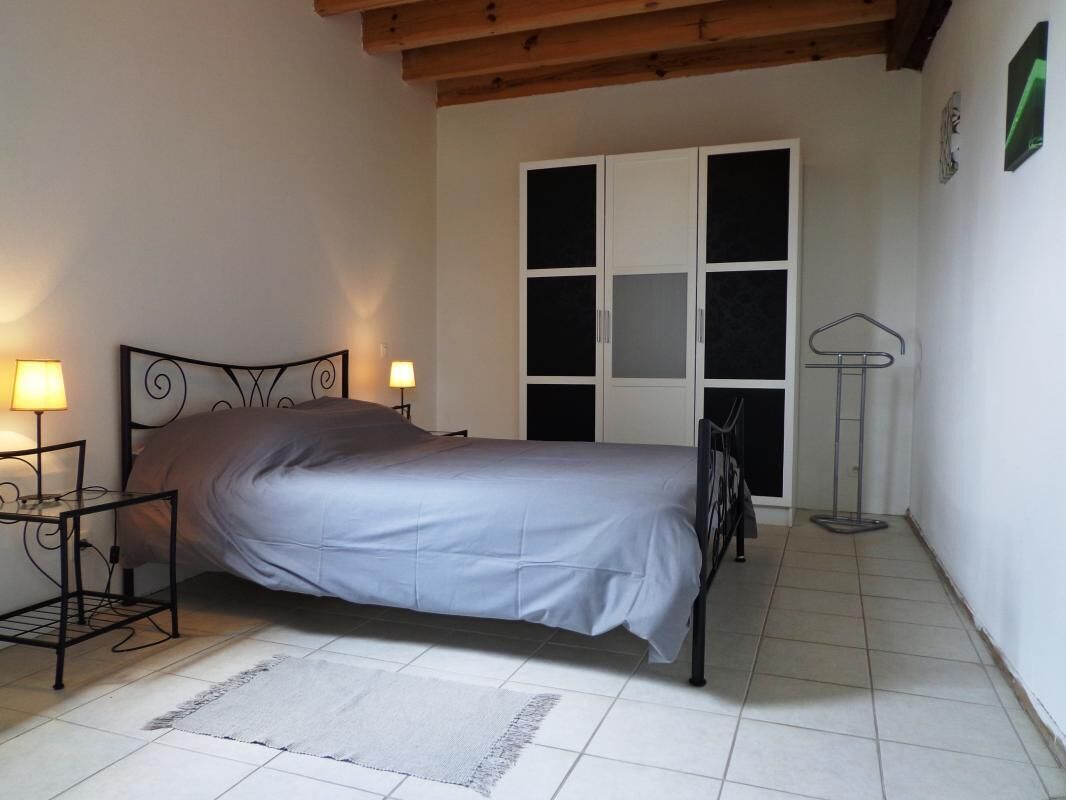 Une chambre à coucher avec un lit, des lampes de chevet, une armoire et une lampe sur pied.